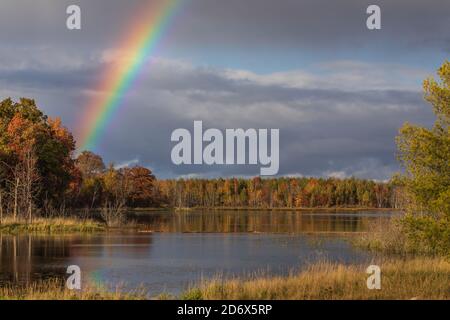 A pretty rainbow over a wilderness lake in northern Wisconsin. Stock Photo