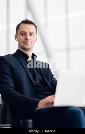 Businessman using laptop with blank screen at public place Stock Photo