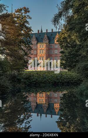 Royal Frederiksborg castle in the woods is reflected in a mirror-shiny pond, Hillerod, Denmark, October 17, 2020 Stock Photo