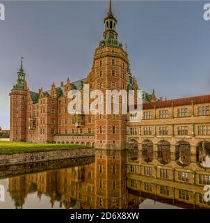 Frederiksborg Castle in the first morning light, reflecting in the moat  from an unusual angle, Hillerod, Denmark, October 17, 2020 Stock Photo