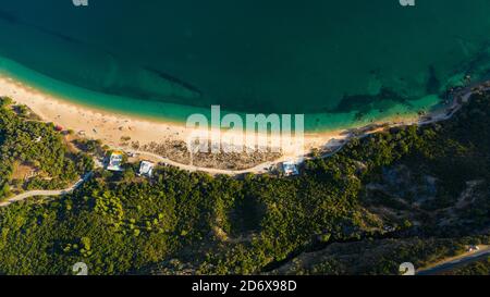 Aerial view of blue Atlantic ocean, green forest mountains and sandy Praia do Portinho da Arrabida beach. Serra da Arrabida, Portugal. Stock Photo