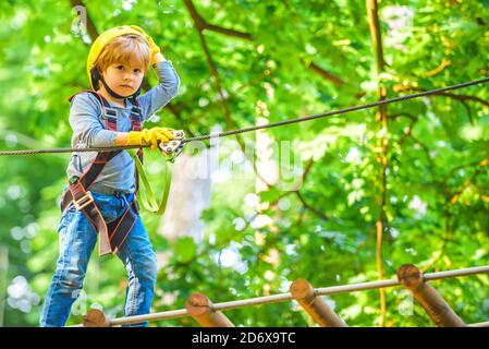 Cute child boy playing. Artworks depict games at eco resort which includes flying fox or spider net. Every childhood matters. Toddler age. Children Stock Photo