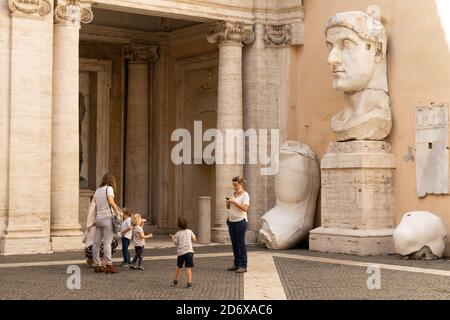 Tourists inside the The Capitoline Museums next to parts of the Colossus of Constantine acrolithic statue in Rome. From a series of travel photos in I Stock Photo