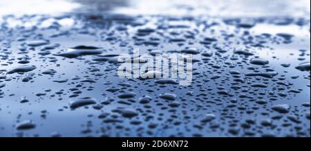 Shiny polished metal surface with water droplets, background photo with selective soft focus Stock Photo