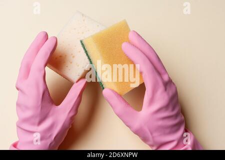 Hands in rubber gloves holding sponges for cleaning. Stock Photo