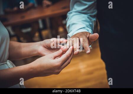 An unrecognizable bride and groom exchanging of the Wedding Rings in wedding ceremony Stock Photo