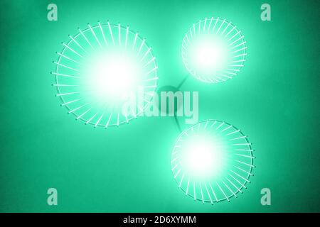 Ceiling lamp on bottom view, green background. Grain on photo. Stock Photo