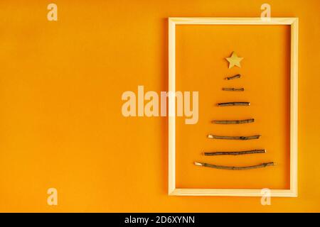 Creative sustainable Christmas tree made of wooden sticks. Minimal DIY design on craft paper background with copy space. No plastic natural design. Stock Photo