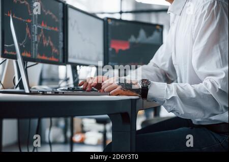 Close up view. Male stockbroker in formal clothes works in the office with financial market Stock Photo