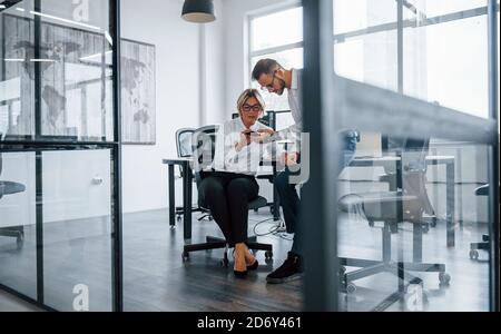 Two stockbrokers in formal clothes works in the office with financial market Stock Photo