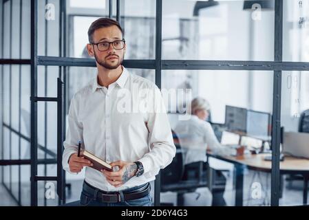 Portrait of young businessman in formal clothes that stands in office Stock Photo