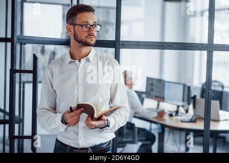 Portrait of young businessman in formal clothes that stands in office Stock Photo
