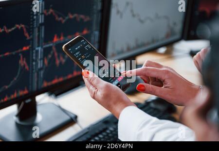 Close up view of people's hands with phone and graphs on it. Stockbrokers have a work Stock Photo
