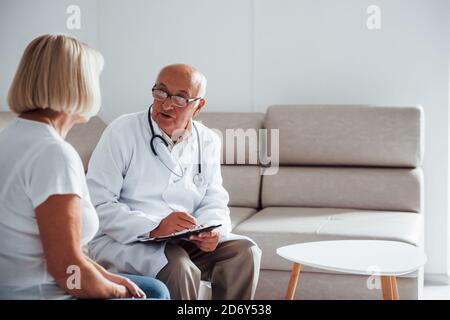 Senior woman have consultation in the clinic by the male doctor Stock Photo