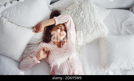 Top view of young beautiful girl wake up in the morning at home Stock Photo
