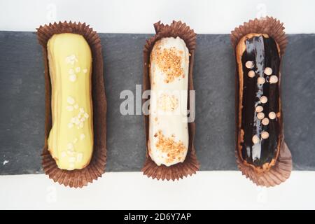 Three eclairs on a black tray top view Stock Photo
