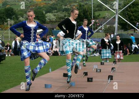 Girvan Lowland Gathering, Ayrshire, Scotland, UK. Highland dancing over swords at an annual event as the girls dressed in traditional costume compete.The Sword Dance is one of the best known of all Highland dances, an ancient dance of war. Performance of sword dances in the folklore of Scotland is recorded from as early as the 15th century Stock Photo