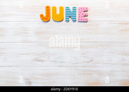 Wooden letters written June month on vintage background. Inscription June with copy space. Top view. Mockup for calendar events. One of 12-month serie Stock Photo