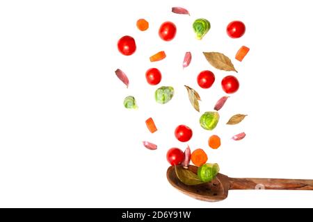 Fresh healthy vegetables over colander isolated on white background. Flying vegetables ingredients over strainer. Vegetable composition. Stock Photo