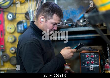 Close-up portrait of male worker at workplace talking on cell phone Stock Photo