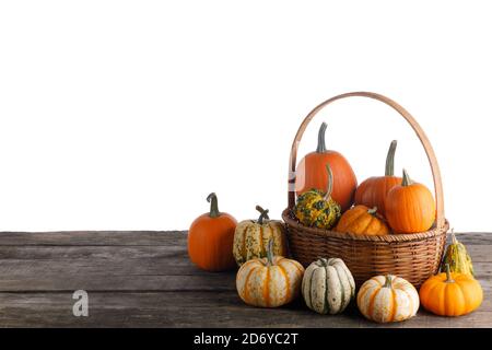 Little pumpkins in basket still life on table isolated on white background Stock Photo