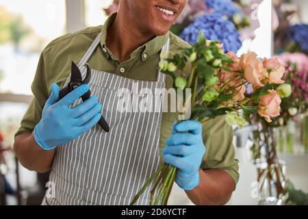 Merry young florist holding bunch of flowers Stock Photo