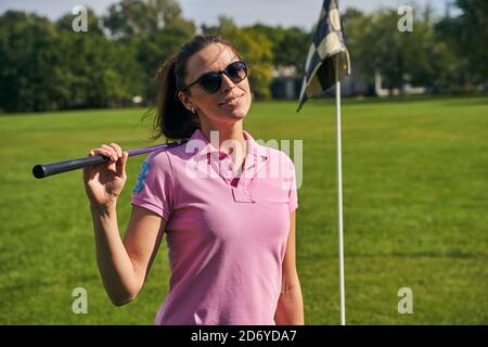 Joyous female golfer in sunglasses posing for the camera Stock Photo