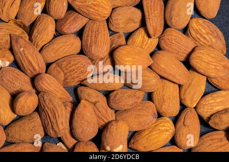 Close up of almonds in dark grey cast iron pan for roasting spices Stock Photo