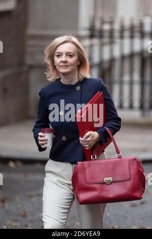 Liz Truss walks up Downing Street to a cabinet meeting on the 20th of October 2020, wearing a navy blue jacket and holding the ministers, red folder.