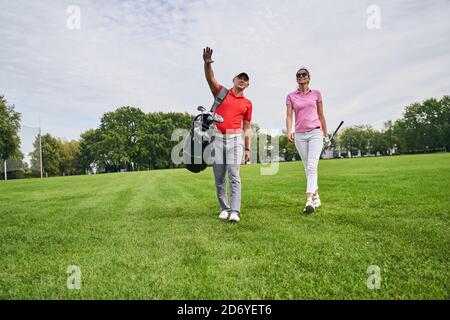 Female golfer and her personal trainer staring into the distance Stock Photo