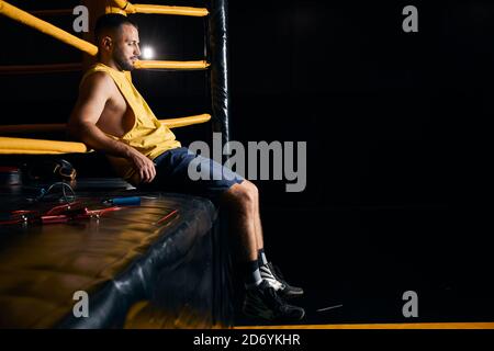 Tired boxer sitting on the side of the ring Stock Photo