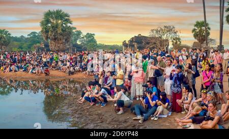 Siem Reap, Cambodia - Mar 3, 2012. A crowd of international tourists is gathered with cameras, waiting for sunrise at Angkor Wat Temple. Stock Photo