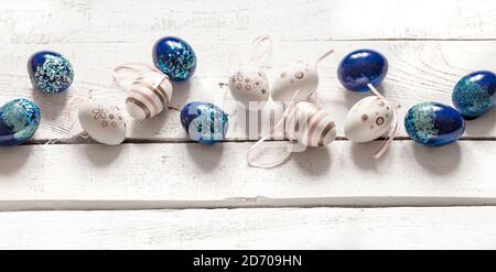 Stylish beautiful composition with blue Easter eggs on a white wooden background. The concept of Easter decorations and celebration. Stock Photo