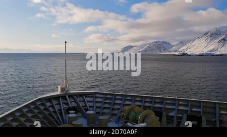 Sørøysundet, Norway - 03/02/2019: Bow of Hurtigruten cruise ship MS Trollfjord in the arctic sea near Sørøya island with snow-covered mountains. Stock Photo