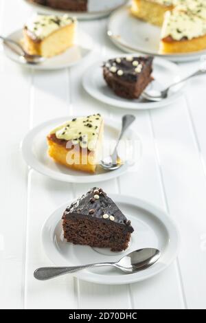 Piece of chocolate and lemon cake on dessert plate on white table. Stock Photo