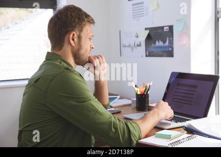 Caucasian man spending time at home, working from home, using laptop computer. Social distancing during Covid 19 Coronavirus quarantine lockdown. Stock Photo