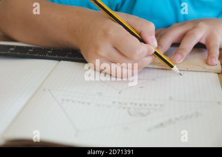 Mid section of Caucasian boy spending time at home, home schooling, doing mathematics homework. Social distancing during Covid 19 Coronavirus quaranti Stock Photo