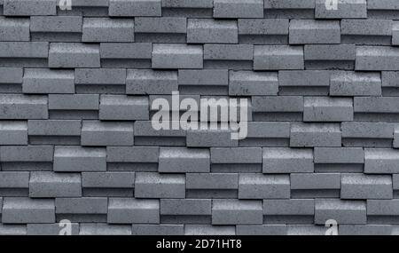 Gray brick wall with simple pattern. Gray wall texture abstract background. Modern design of brick wall background. Simple abstract wallpaper. Stock Photo