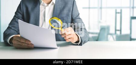 businessman or tax inspector analyzing document with magnifying glass in office. business financial audit concept. copy space Stock Photo