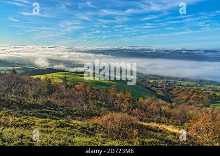 Lookimg west from slope of Pennycloddiau Mountain in the Clwydian Range in morning light with low cloud streaming down the Vale of Clwyd  North Wales Stock Photo