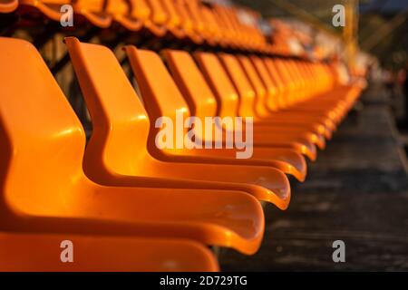 Close up view of stadium seats on orange color, selective focus. Stock Photo