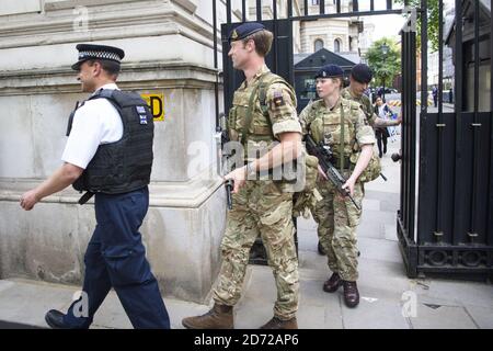 Members of the army join police officers outside Downing Street, London, after Scotland Yard announced armed troops will be deployed to guard 'key locations' such as Buckingham Palace, Downing Street, the Palace of Westminster and embassies. Picture date: Wednesday May 24th, 2017. Photo credit should read: Matt Crossick/ EMPICS Entertainment. Stock Photo