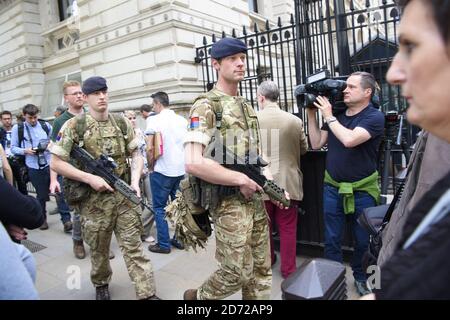 Members of the army join police officers outside Downing Street, London, after Scotland Yard announced armed troops will be deployed to guard 'key locations' such as Buckingham Palace, Downing Street, the Palace of Westminster and embassies. Picture date: Wednesday May 24th, 2017. Photo credit should read: Matt Crossick/ EMPICS Entertainment. Stock Photo