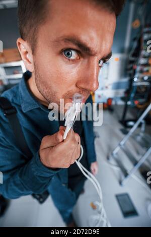 Close up view of funny man with internet wires in server room Stock Photo