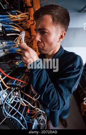 Close up view of funny man with internet wires in server room Stock Photo