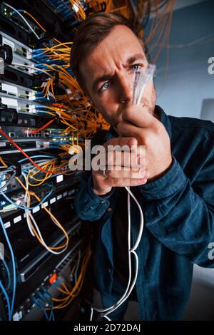 Close up view of funny man with internet wires in server room Stock Photo