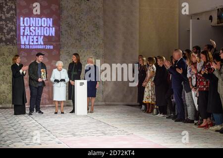 Queen Elizabeth II presents the Queen Elizabeth II Award for British Design to designer Richard Quinn, after his London Fashion Week show, held at the BFC showspace, London. Picture date: Tuesday February 20th 2018. Photo credit should read: Matt Crossick/ EMPICS Entertainment. Stock Photo