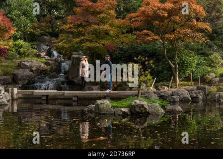 London, UK.  20 October 2020. UK Weather - Visitors enjoy the autumnal display of changing leaves in the Japanese themed Kyoto Garden in Holland Park. The forecast is for a heavy rain to arrive in the next few days across much of the UK.  Credit: Stephen Chung / Alamy Live News Stock Photo