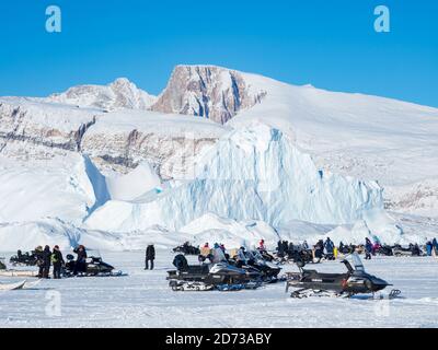 Sleddog race on frozen fjord, Saatut near Uummannaq.  Spectators are arriving by dog sled or snowmobile. Qualifier for the greelandic championships 20 Stock Photo