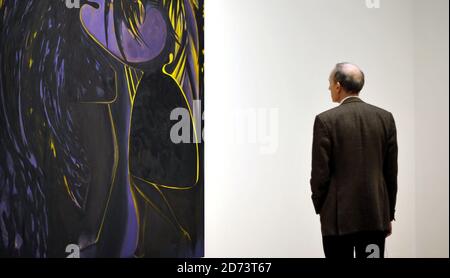 Visitors look at works by Chris Ofili on display at a new exhibition of ...